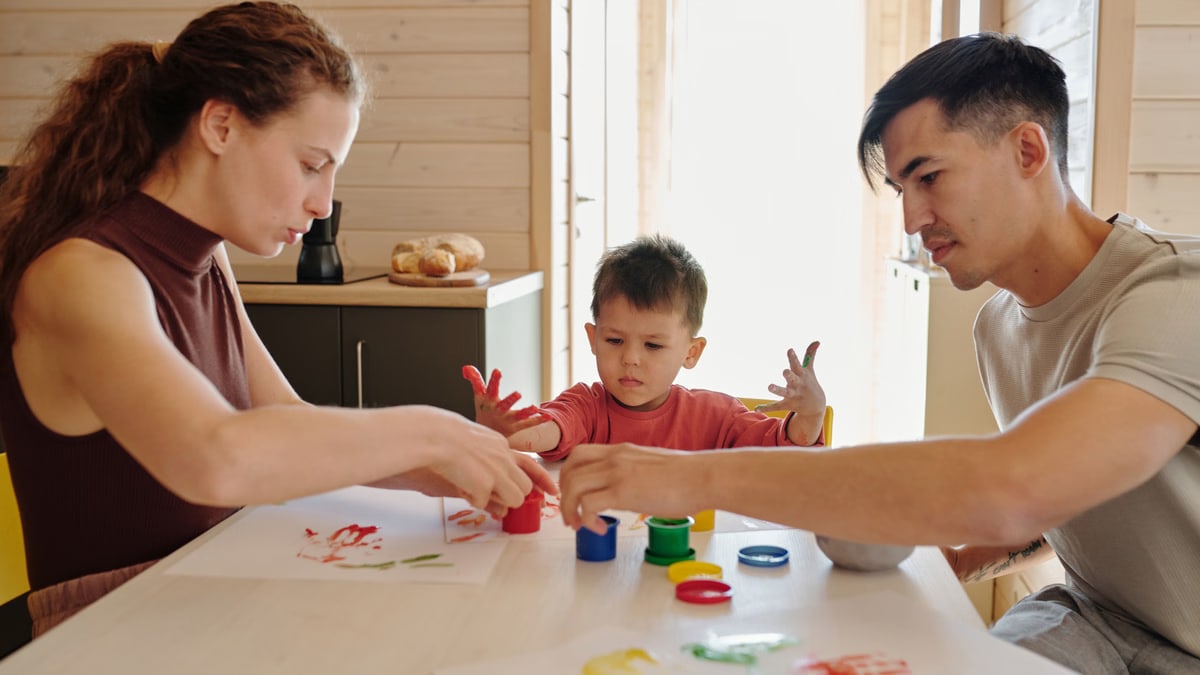 Family enjoying a creative painting session indoors, fostering bonding and creativity.